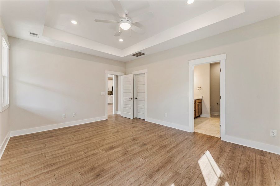 This primary bedroom offers warm wood flooring and This primary bedroom offers warm wood flooring and