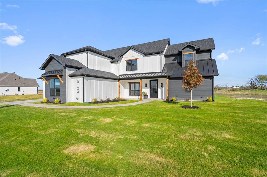 Modern farmhouse style home featuring a front yard