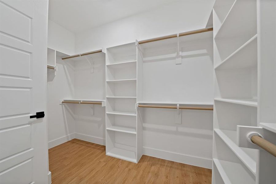 Spacious closet with light wood finished floors