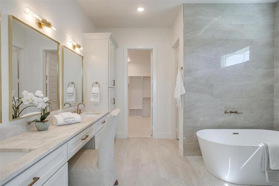 Bathroom featuring a bath, tile walls, and vanity