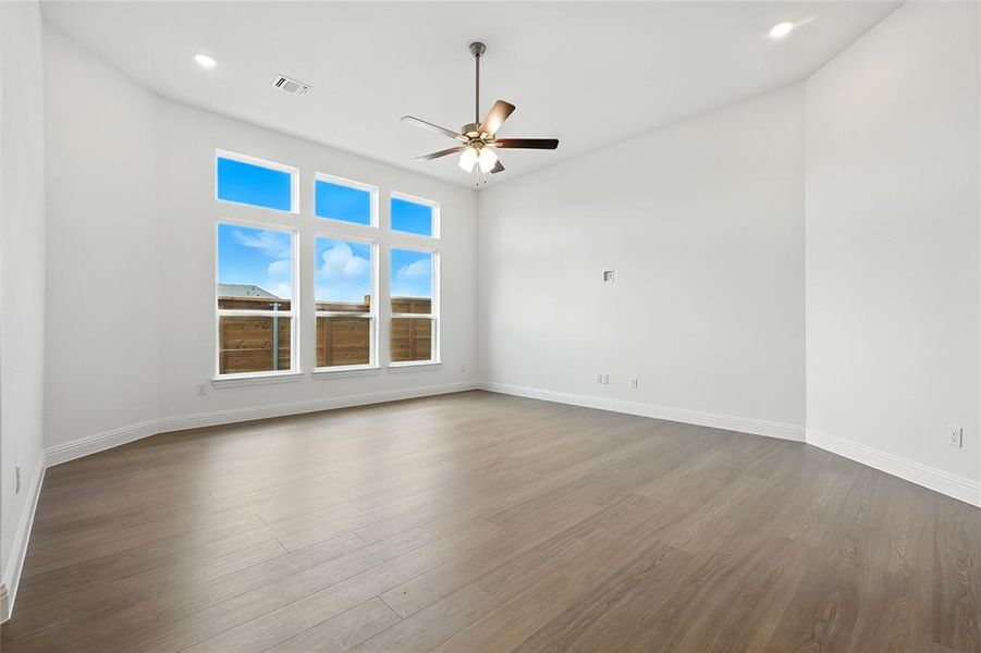 Empty room with wood finished floors, a ceiling fan, and recessed lighting