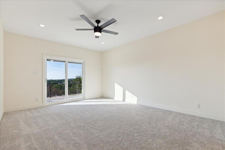 Carpeted spare room featuring ceiling fan