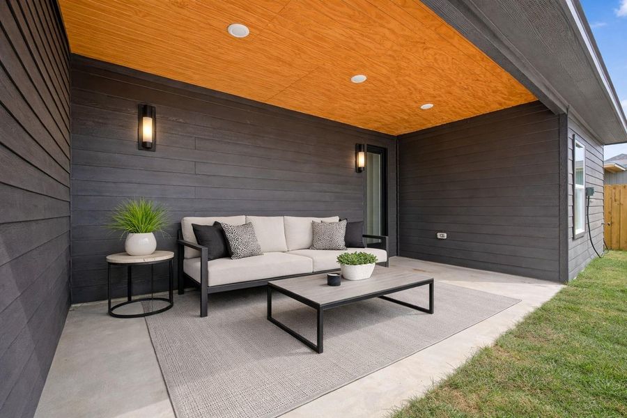 Oversized covered patio with wood-accented ceiling and LED lighting, perfect for outdoor entertaining. Virtually staged.