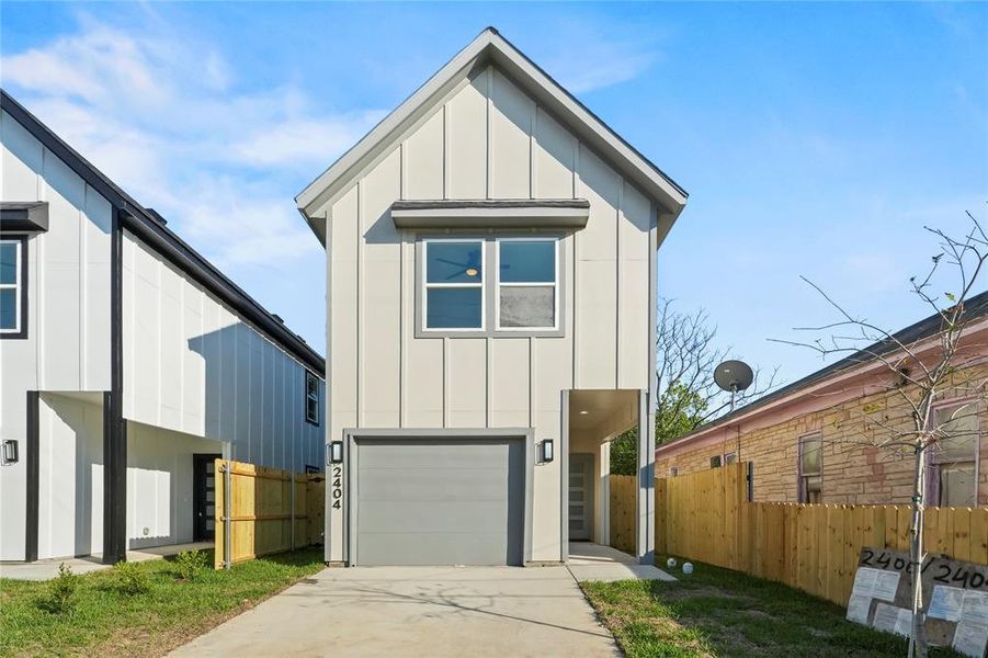 Contemporary house featuring board and batten siding, driveway, and a garage
