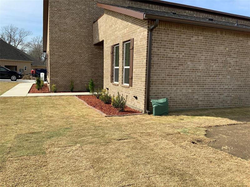 View of side of property with brick siding and a lawn View of side of property with brick siding and a lawn