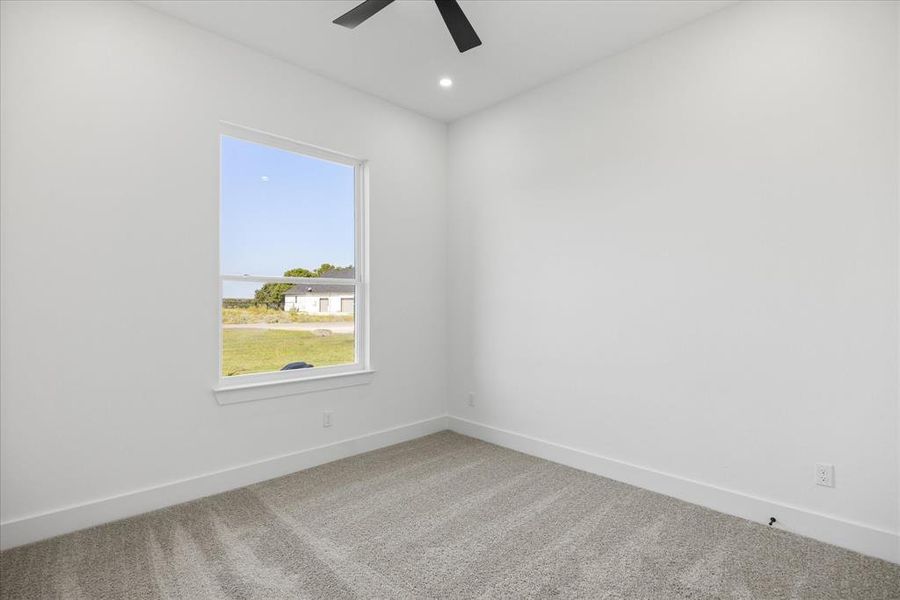 Bright interior Kids/Guest front facing bedroom with a single window, recessed lighting, and a ceiling fan