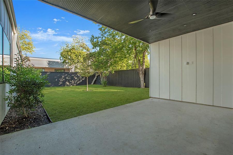 View of yard with ceiling fan and a patio