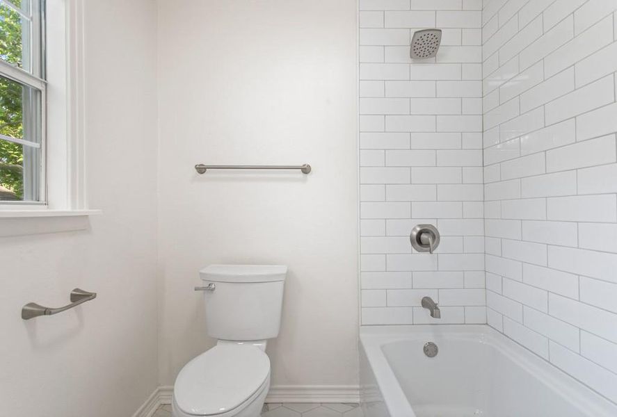 Full bath featuring baseboards, toilet, shower / tub combination, and tile patterned floors