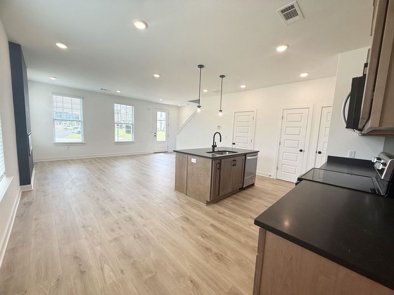 Kitchen featuring dishwasher, dark countertops, black / electric stove, open floor plan, and recessed lighting