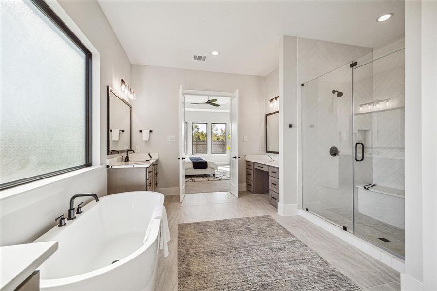 Primary bath with split vanities, a 67” soaking tub and an oversized shower. 2 closets complete the space.