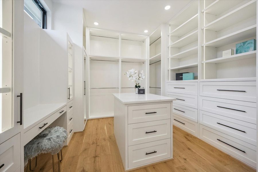 Modern closet featuring a generous island with dual storage on both sides. Modern closet featuring a generous island with dual storage on both sides.