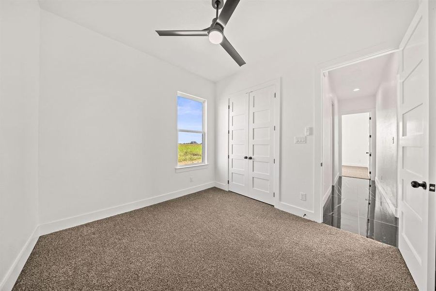 Unfurnished bedroom with dark colored carpet and baseboards Unfurnished bedroom with dark colored carpet and baseboards