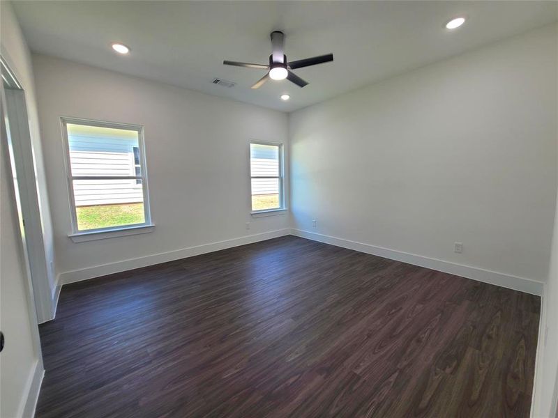 Empty room featuring dark hardwood / wood-style floors and ceiling fan