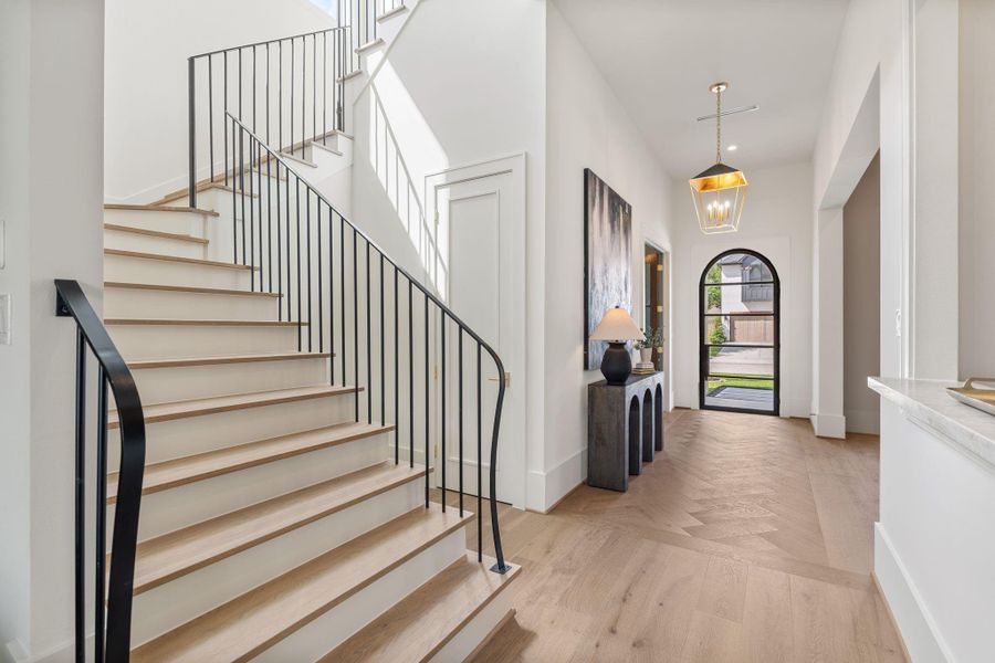 The staircase showcases clean lines with modern iron balusters and wood treads, complementing the home’s transitional style. Positioned near the entry, it enhances the home’s open yet defined layout.