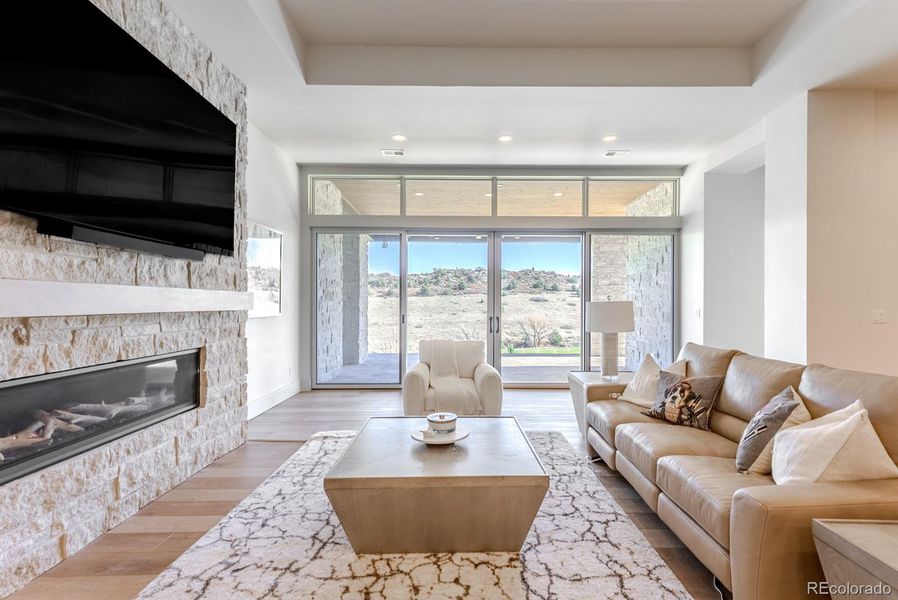 This light-filled walkout basement family room offers a refined yet relaxed gathering space, where expansive windows frame uninterrupted views of the golf course and fill the room with natural light.