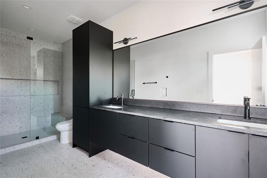 Primary bathroom with modern tile and large dual vanities