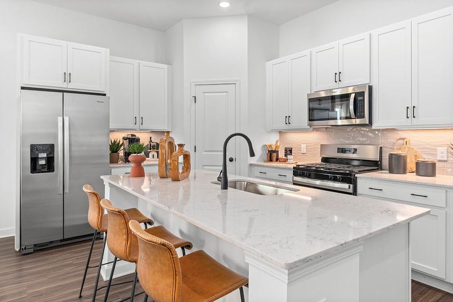 A kitchen with white cabinets.
