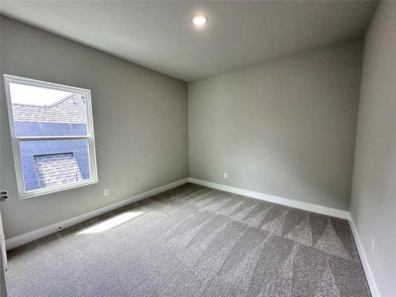 Secondary upstairs bedroom featuring light colored carpet