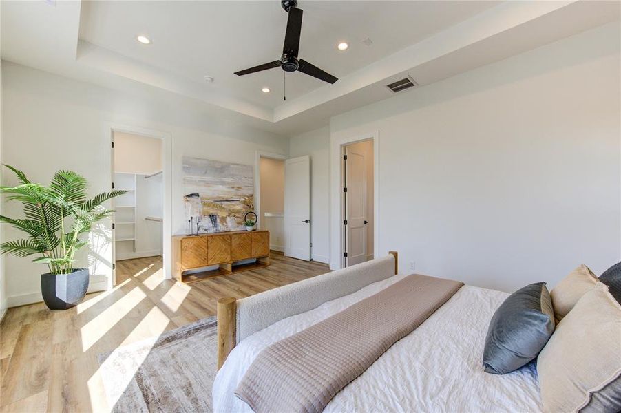 This oversized primary bedroom on the 3rd floor features a tray ceiling and tons of natural light. Includes two walk-in closets: one in the bedroom and the other in the bathroom.