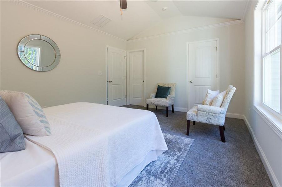 Carpeted bedroom with lofted ceiling and ceiling fan