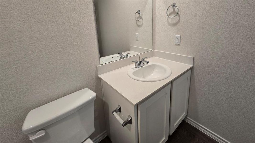 Bathroom featuring a textured wall and vanity