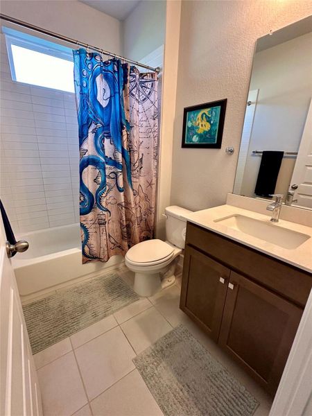 Full bathroom featuring a single vanity with a white countertop and dark wood-finish cabinetry.