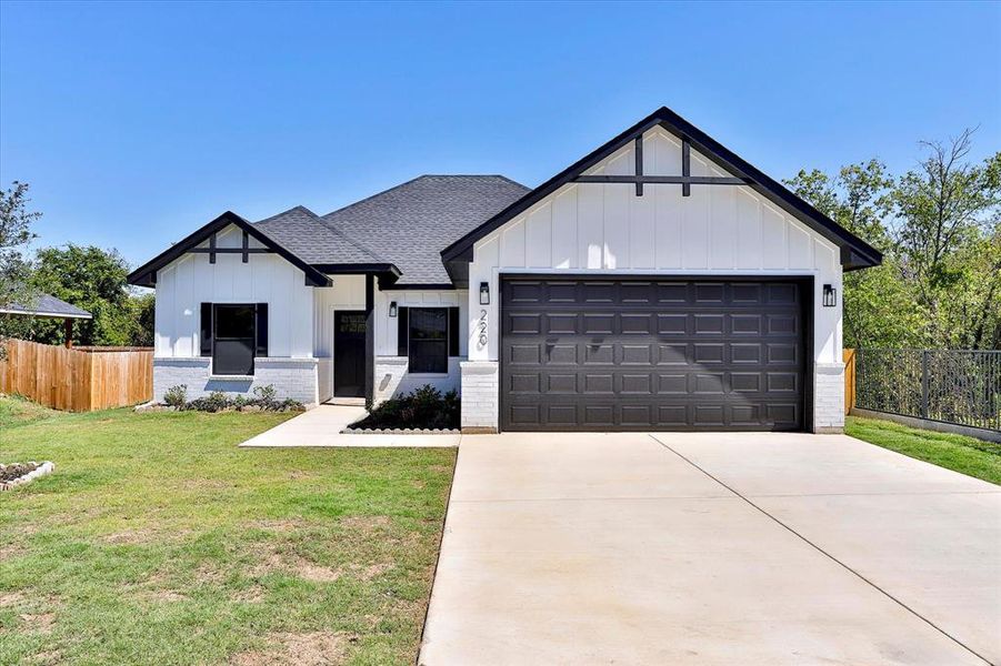 Modern inspired farmhouse with a garage and a front yard