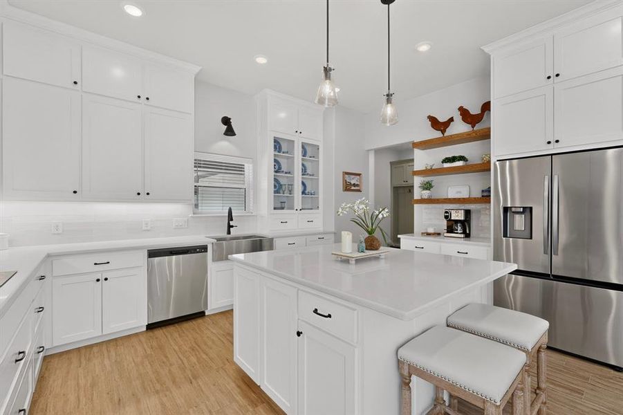 Pendants over island add to the ambiance and check out the wood floating shelves for added architectural feature