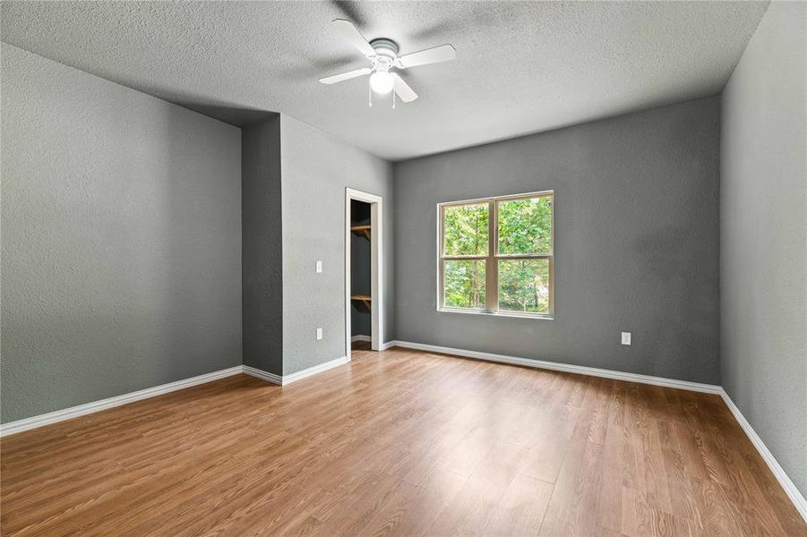 Spare room featuring ceiling fan, a textured ceiling, and hardwood / wood-style flooring Spare room featuring ceiling fan, a textured ceiling, and hardwood / wood-style flooring