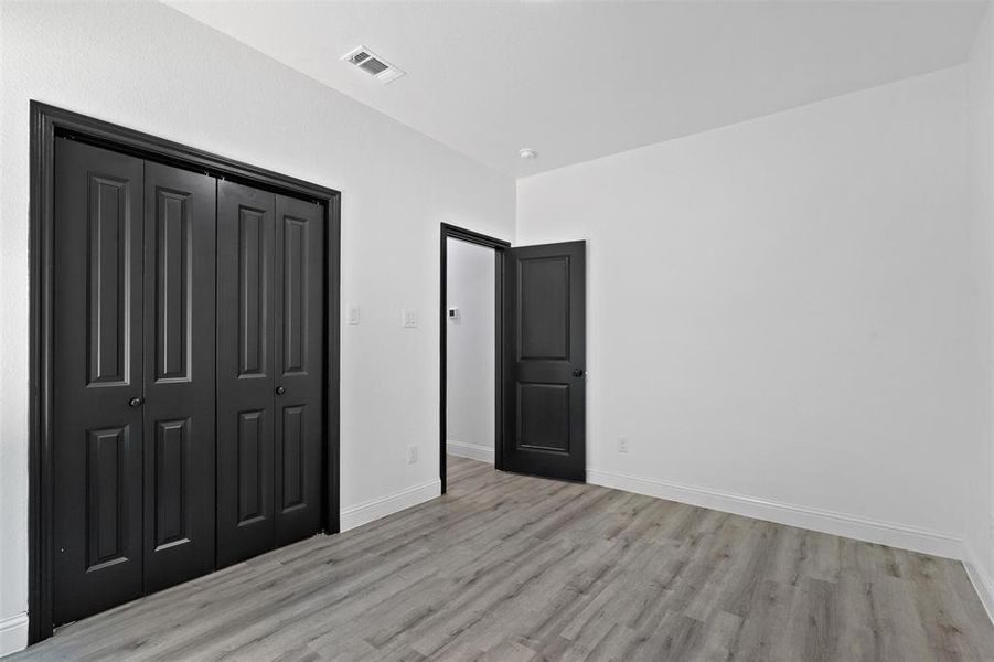 Unfurnished bedroom featuring a closet and light hardwood / wood-style flooring