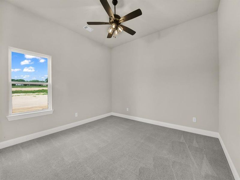 Unfurnished room with carpet flooring, baseboards, and ceiling fan Unfurnished room with carpet flooring, baseboards, and ceiling fan