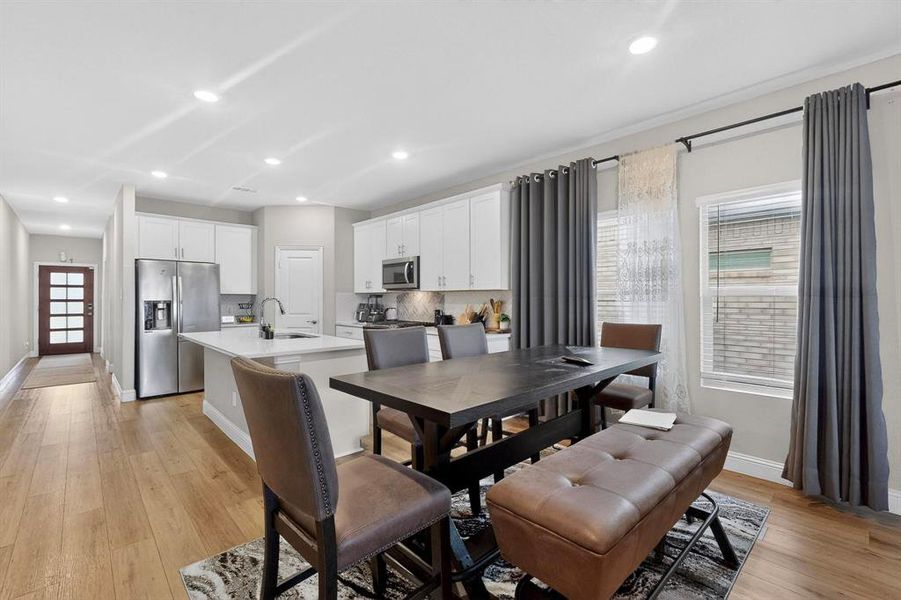 Dining area with light wood finished floors and recessed lighting Dining area with light wood finished floors and recessed lighting