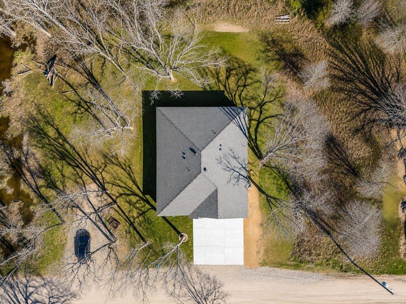 Aerial perspective showcasing a single-story residence with a gray shingle roof Aerial perspective showcasing a single-story residence with a gray shingle roof