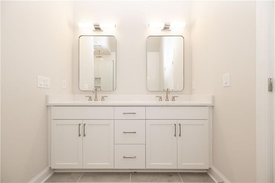 Primary bathroom features double vanity with framed mirrors and upgraded lighting- and high ceilings. Image is of previously built Chamberlain