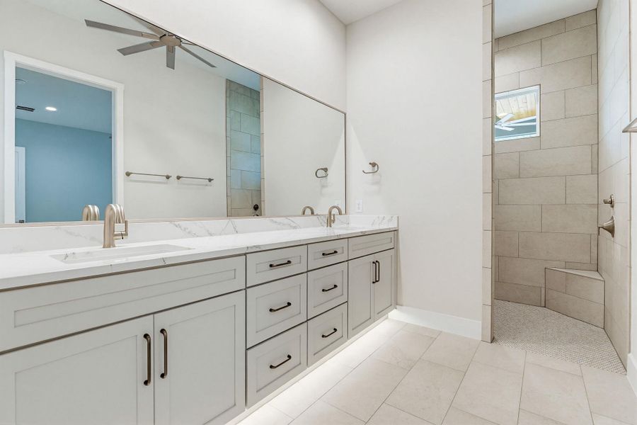 Marble countertops and a dual vanity with ample storage create a serene, functional primary bathroom.