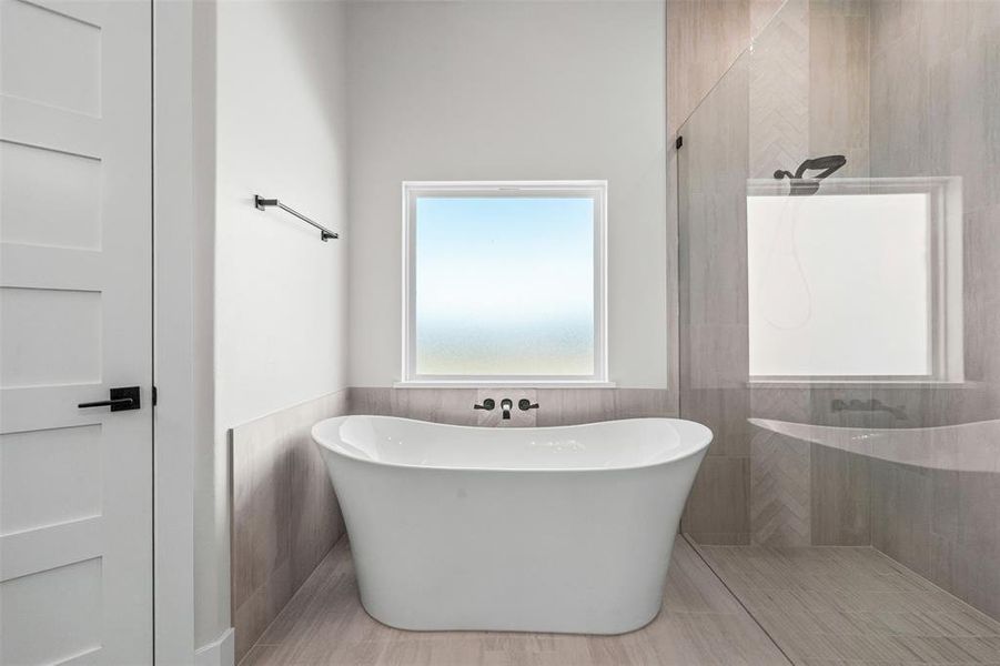 Full bathroom featuring wainscoting, walk in shower, a freestanding tub, and tile walls