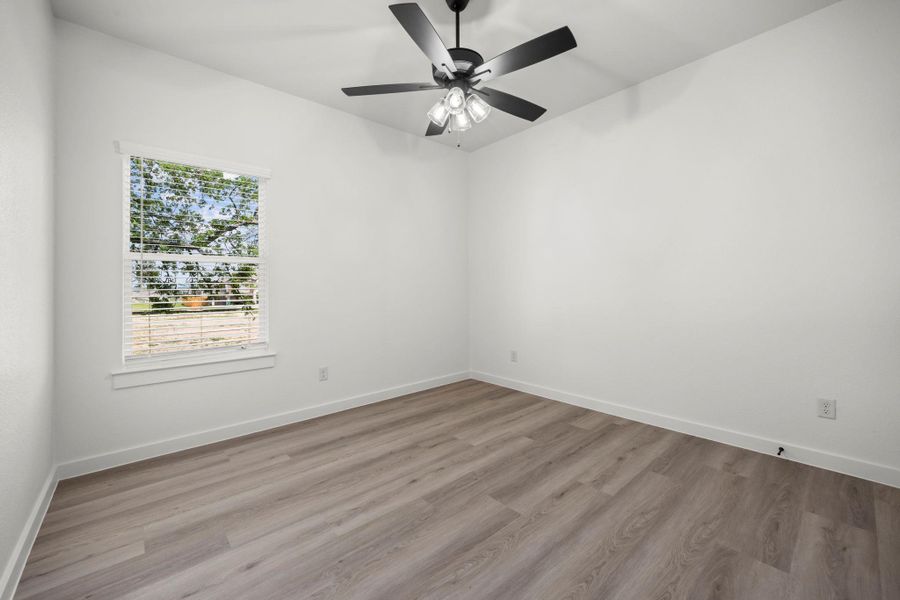 A well-lit room features durable laminate flooring and a modern ceiling fan for comfort. A well-lit room features durable laminate flooring and a modern ceiling fan for comfort.