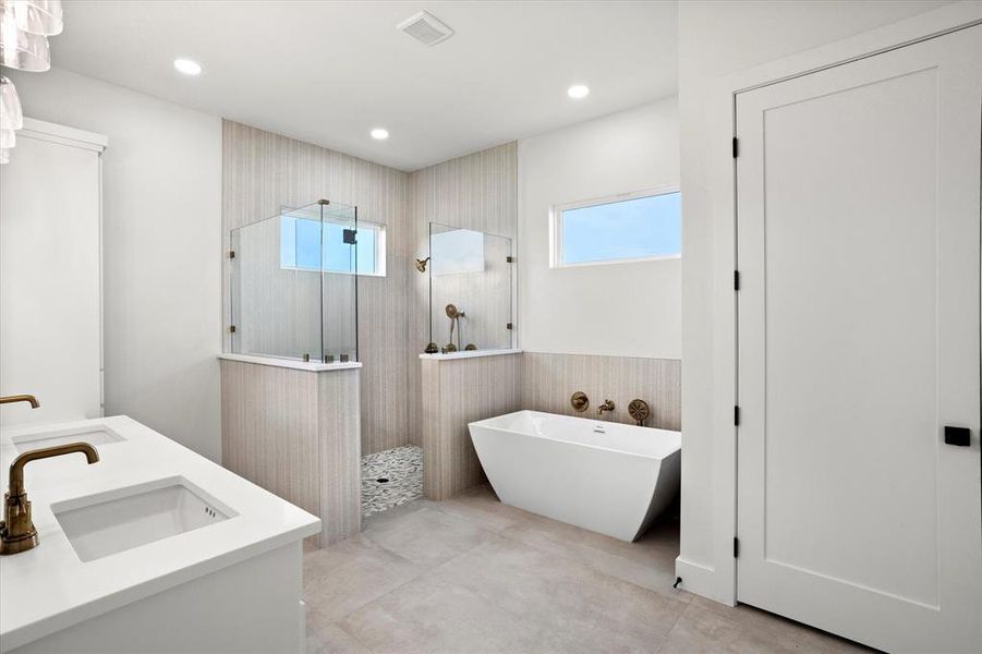 Full bathroom with walk in shower, a soaking tub, plenty of natural light, double vanity, and recessed lighting Full bathroom with walk in shower, a soaking tub, plenty of natural light, double vanity, and recessed lighting
