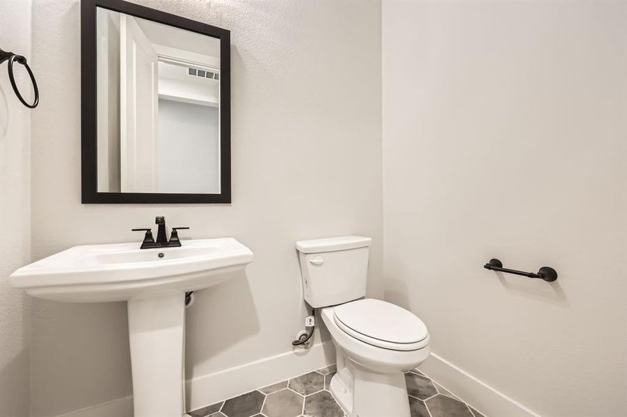 Bathroom with tile patterned floors, toilet, baseboards, and visible vents Bathroom with tile patterned floors, toilet, baseboards, and visible vents