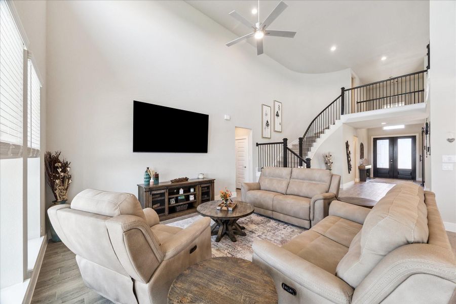 Bright living area with soaring ceilings, wall of windows, and open flow to the foyer and upstairs landing. Bright living area with soaring ceilings, wall of windows, and open flow to the foyer and upstairs landing.