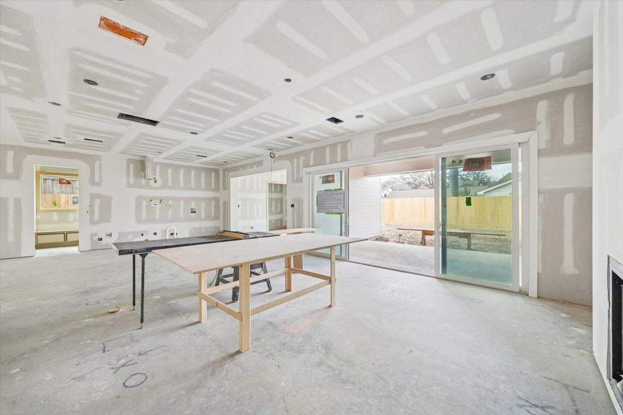 Soaring ceilings with recessed lighting create a bright, open living space that flows effortlessly to oversized sliding glass doors and the covered patio with outdoor grill. Expansive rear windows and clean architectural lines define this custom Oak Forest new construction by Harvard Homes.