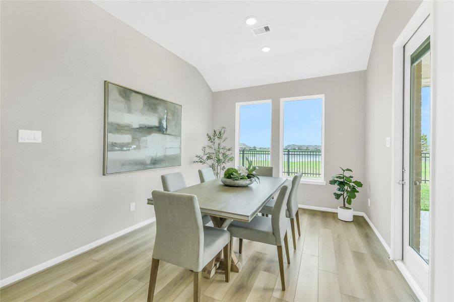 Dedicated cafe/dining area with wall-to-wall windows overlooking the lakefront backyard.