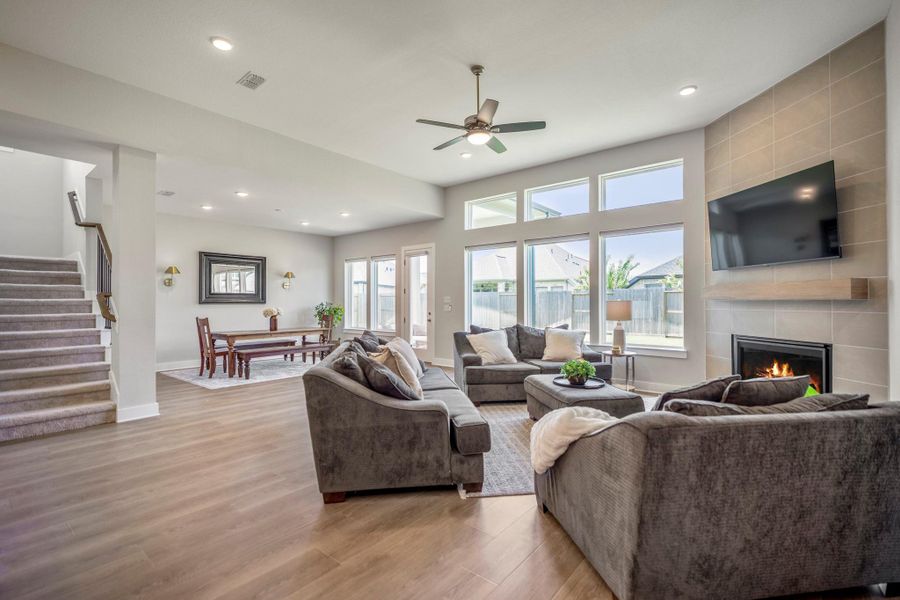 Open, airy and made for real life, this inviting family room brings everyone together with LVP flooring, a gas-log fireplace, stacked windows and an easy flow to the dining area, kitchen and covered patio.