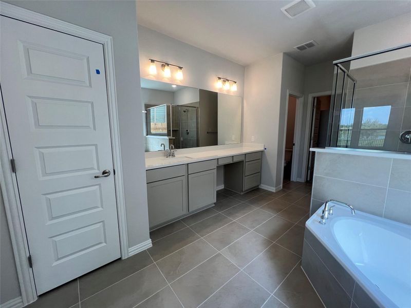 Full bath featuring a shower stall, vanity, a garden tub, and light tile patterned floors