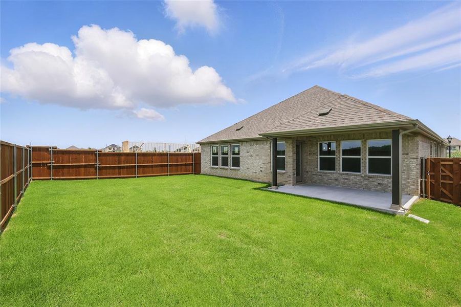 Rear view of house with roof with shingles, a patio, and brick siding Rear view of house with roof with shingles, a patio, and brick siding