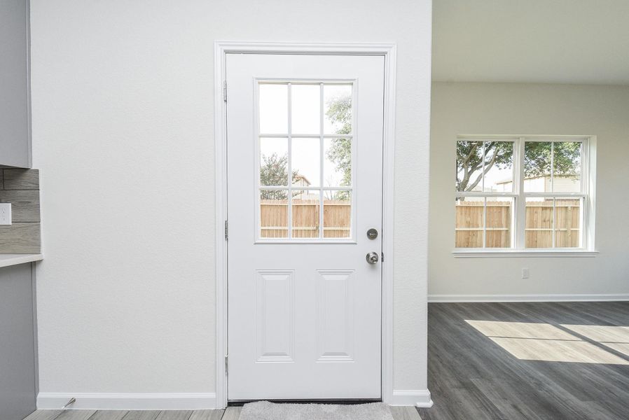 This photo showcases a bright and airy space featuring a modern front door with glass panes, sleek laminate flooring, and a large window that lets in plenty of natural light, overlooking a fenced backyard. This photo showcases a bright and airy space featuring a modern front door with glass panes, sleek laminate flooring, and a large window that lets in plenty of natural light, overlooking a fenced backyard.