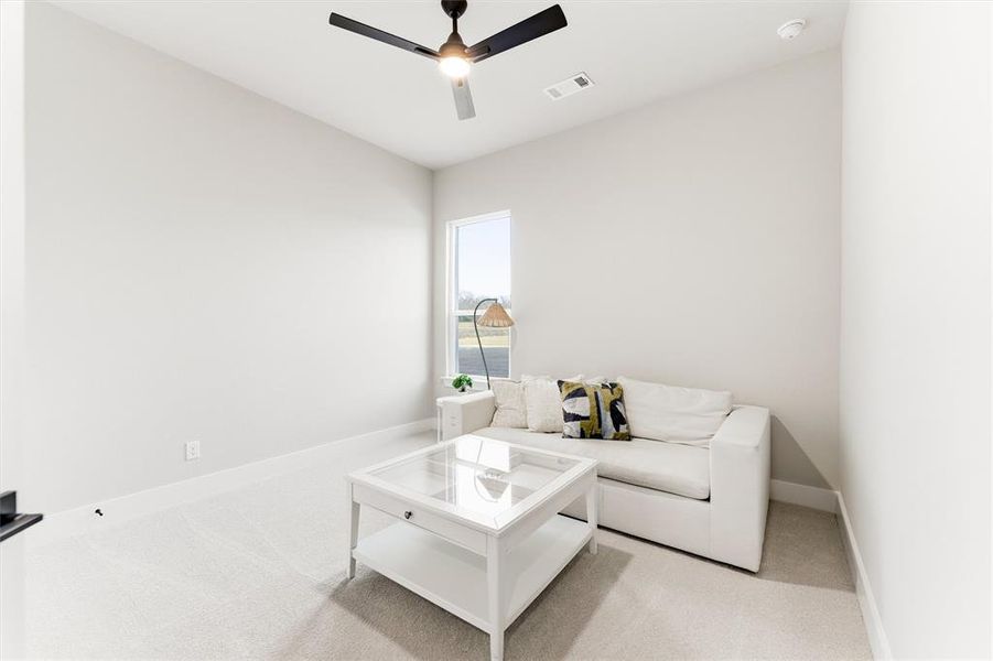 Living room featuring carpet flooring and ceiling fan