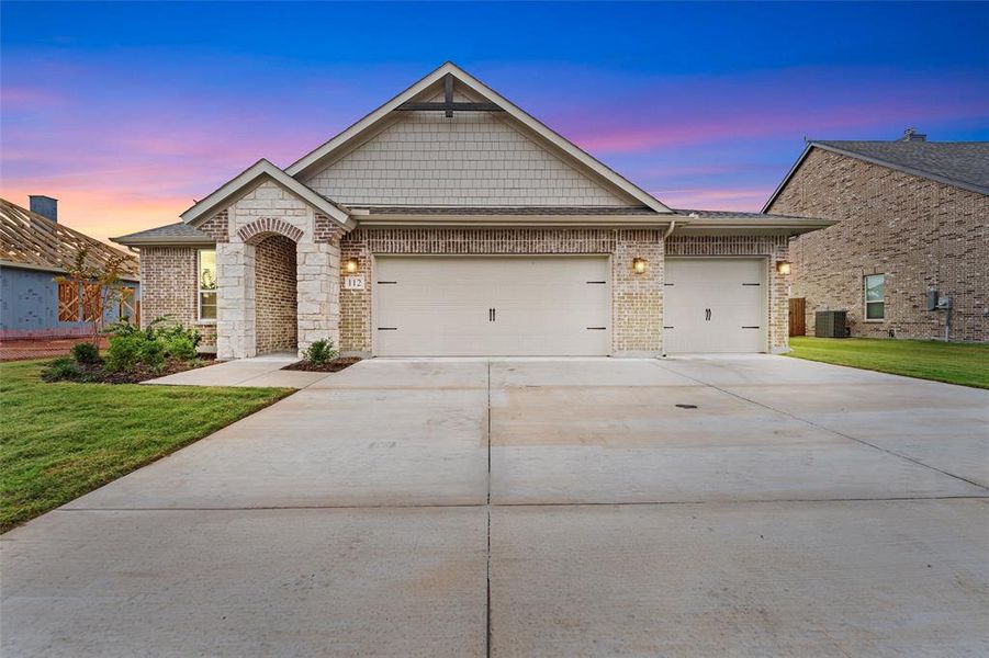 View of front facade with brick siding, driveway, a yard, and a garage View of front facade with brick siding, driveway, a yard, and a garage