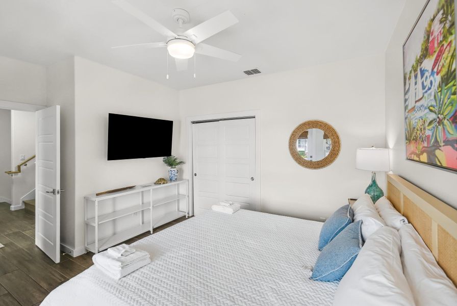 Bedroom featuring wood finished floors, a ceiling fan, and a closet Bedroom featuring wood finished floors, a ceiling fan, and a closet