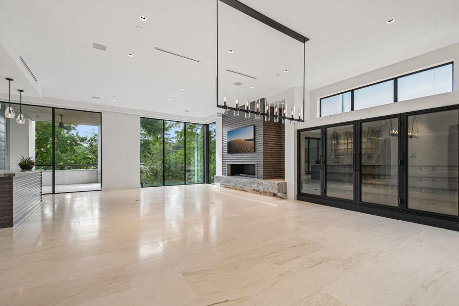 Polished tile flooring, a sleek linear fireplace, and floor-to-ceiling glass anchor this modern main level. Polished tile flooring, a sleek linear fireplace, and floor-to-ceiling glass anchor this modern main level.